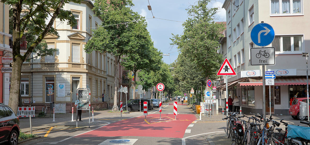 Foto des modalen Filters an der Kreuzung Sophienstraße/Lessingstraße. Zu sehen ist eine Reihe Sperrpfosten quer über die Fahrbahn und ein Verkehrszeichen "vorgeschriebene Fahrtrichtung rechts, Radfahrer frei"