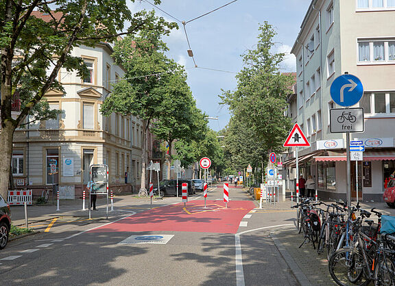 Foto des modalen Filters an der Kreuzung Sophienstraße/Lessingstraße. Zu sehen ist eine Reihe Sperrpfosten quer über die Fahrbahn und ein Verkehrszeichen "vorgeschriebene Fahrtrichtung rechts, Radfahrer frei"